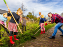 Kinderen en een ouder wieden onkruid in een tuin