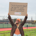 Vrouw houdt bord omhoog met oproep meedoen aan NLdoet